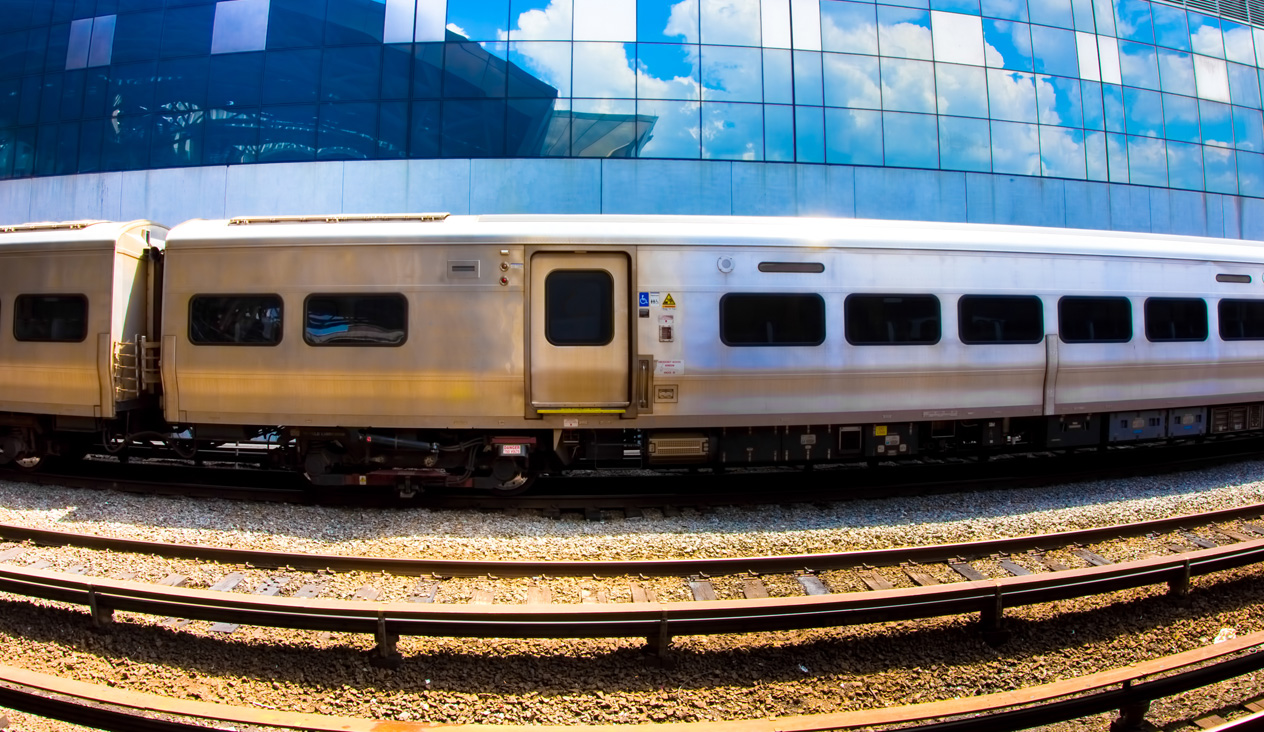 Train in front of reflective building